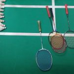green and white court with badminton rackets