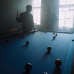 man in black and white striped long sleeve shirt playing billiard