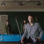 man in black and white striped long sleeve shirt standing beside man in black and white