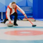 sportsman playing curling on ice