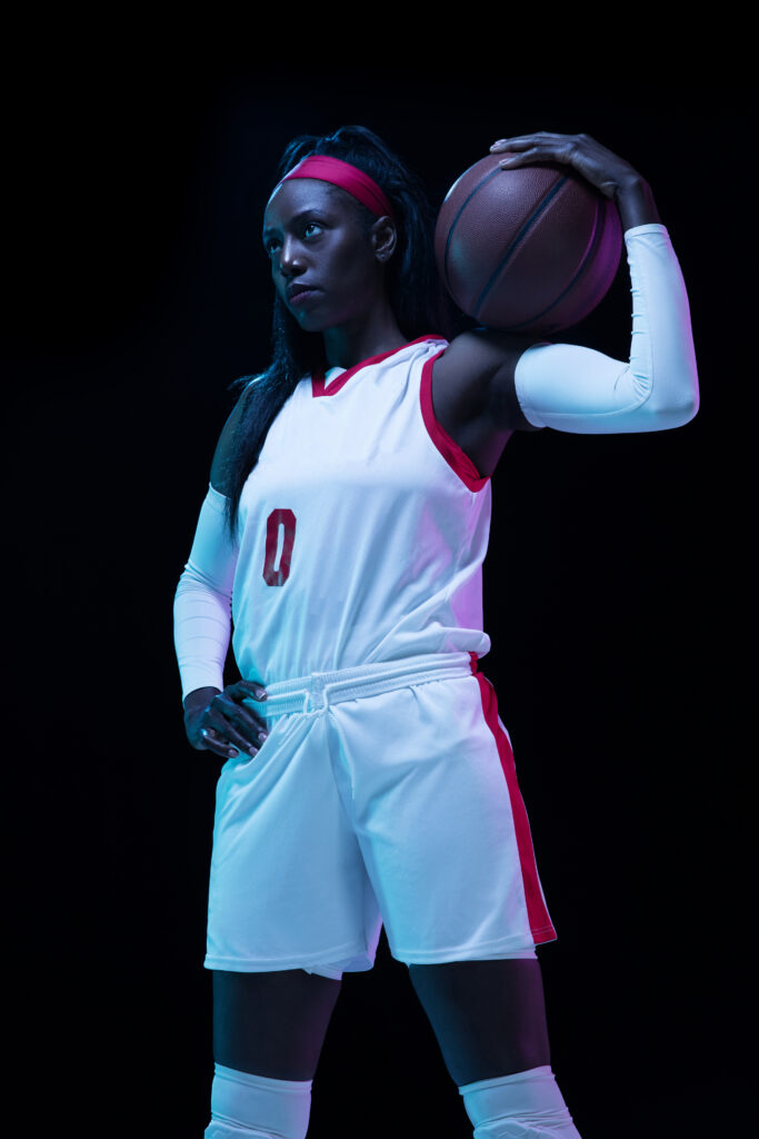 Championship. Beautiful african-american female basketball player in motion and action in neon light on black background. Concept of healthy lifestyle, professional sport, hobby. Woman in sport.