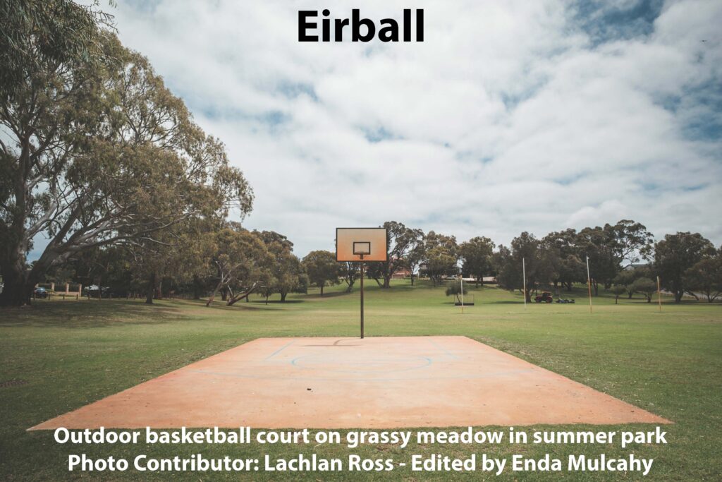 Outdoor basketball court on grassy meadow in summer park